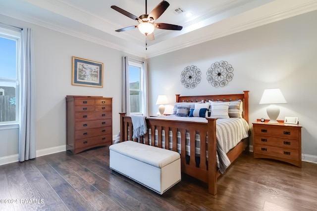 bedroom featuring ornamental molding, dark hardwood / wood-style floors, a tray ceiling, and ceiling fan