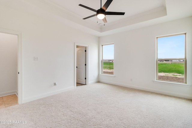 unfurnished room featuring a tray ceiling, ornamental molding, light colored carpet, and ceiling fan