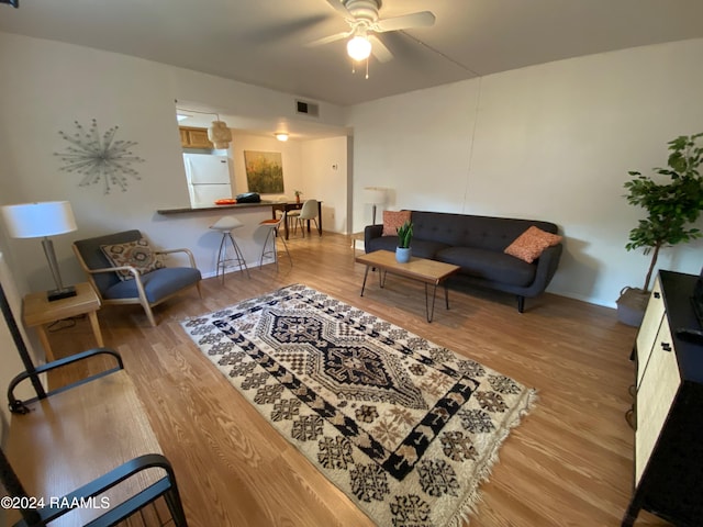 living room with wood-type flooring and ceiling fan