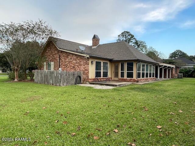 rear view of house featuring a yard and a patio area