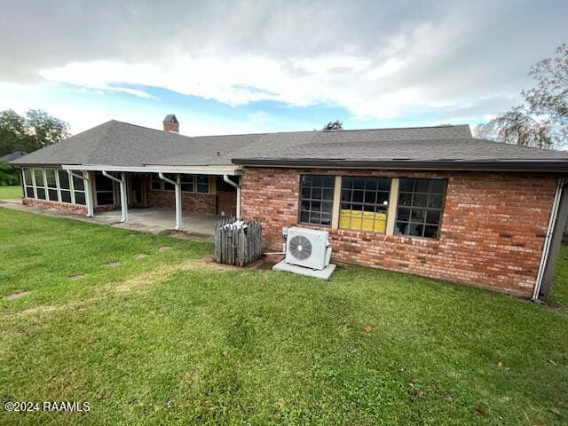 back of house featuring a lawn, a patio area, and ac unit