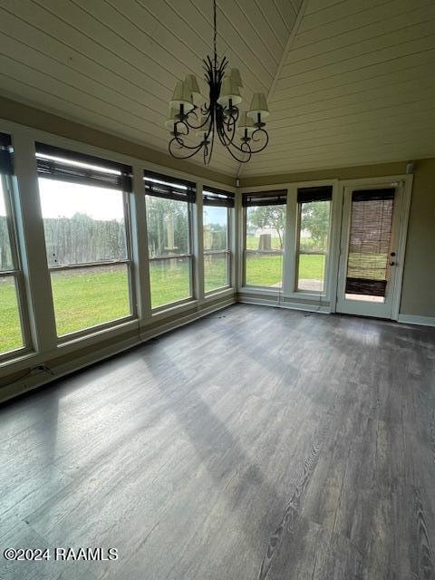 unfurnished sunroom with a chandelier, a wealth of natural light, and lofted ceiling