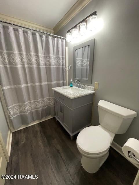 bathroom with hardwood / wood-style floors, vanity, crown molding, a shower with shower curtain, and toilet