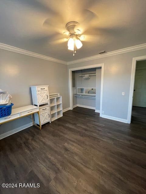 unfurnished bedroom with ceiling fan, a closet, dark wood-type flooring, and ornamental molding