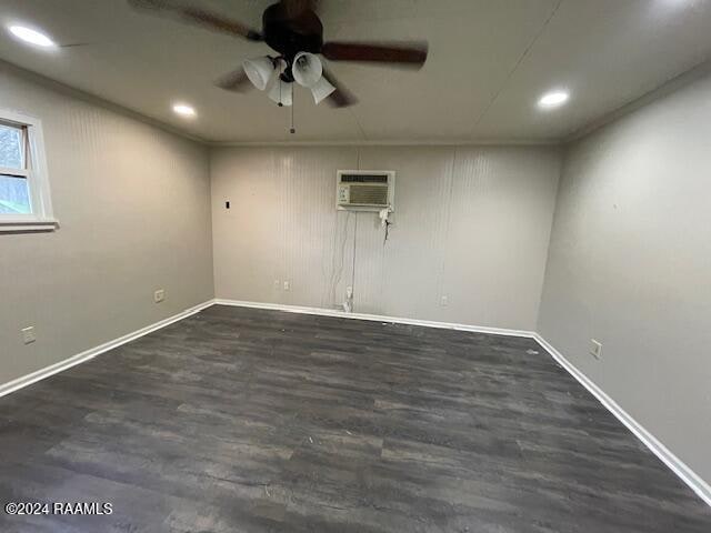 basement with ceiling fan, dark hardwood / wood-style flooring, and a wall mounted AC