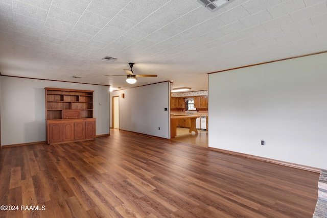 unfurnished living room featuring ceiling fan, sink, and dark hardwood / wood-style floors