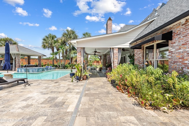 view of pool with ceiling fan, a gazebo, pool water feature, and a patio area