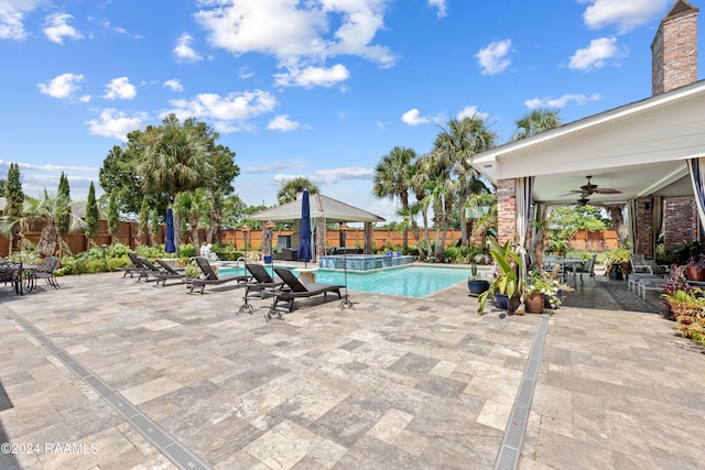 view of swimming pool featuring a gazebo, a patio area, ceiling fan, and an in ground hot tub