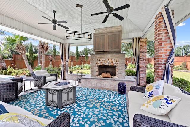 view of patio with ceiling fan and an outdoor living space with a fireplace