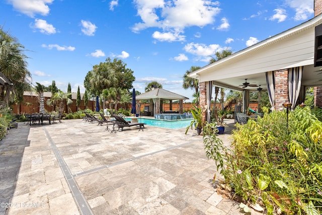 view of swimming pool featuring ceiling fan, a patio area, and a gazebo