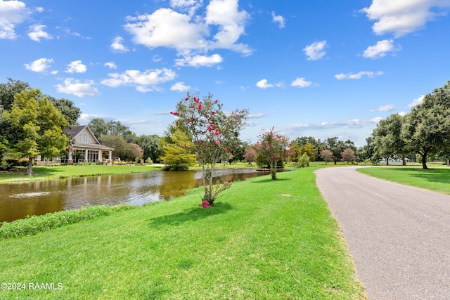 surrounding community featuring a water view and a lawn