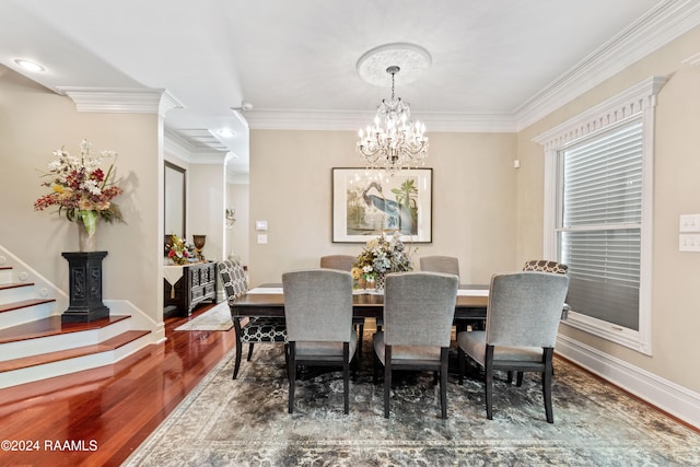 dining room featuring wood-type flooring, a notable chandelier, and ornamental molding