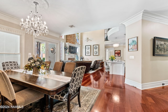 dining space featuring hardwood / wood-style flooring, ceiling fan with notable chandelier, and crown molding