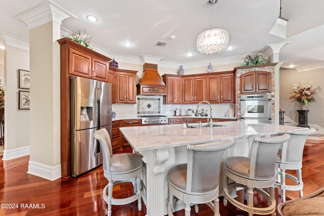 kitchen featuring premium range hood, appliances with stainless steel finishes, decorative light fixtures, a large island, and dark hardwood / wood-style floors