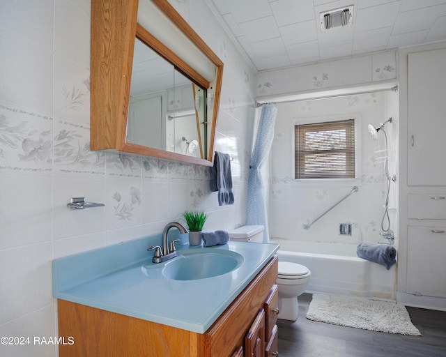 full bathroom featuring vanity, wood-type flooring, tile walls, and tub / shower combination