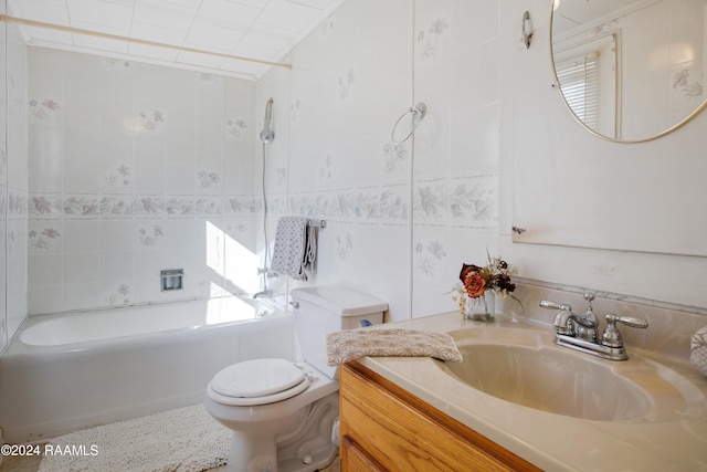 full bathroom with tile walls, vanity, tiled shower / bath combo, and toilet