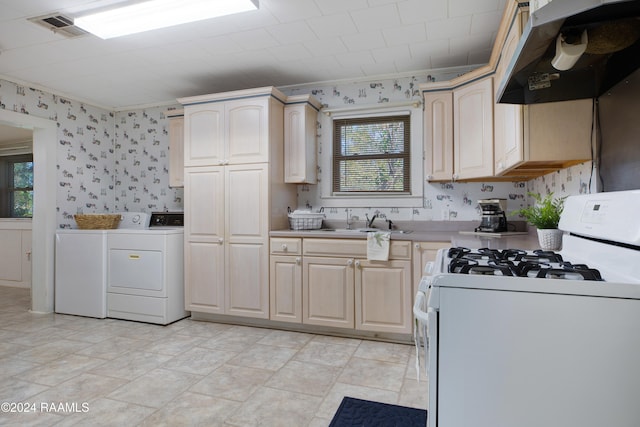 kitchen featuring separate washer and dryer, a healthy amount of sunlight, white gas stove, and exhaust hood