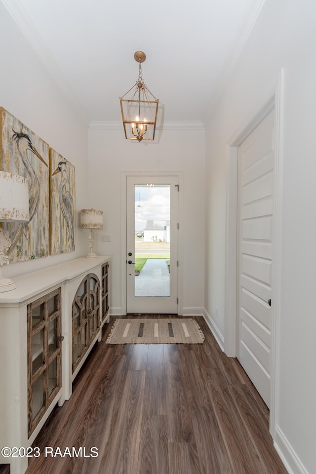 entryway with dark hardwood / wood-style flooring, a chandelier, and ornamental molding