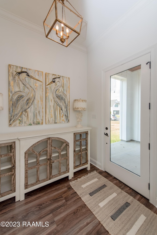 entryway with dark hardwood / wood-style flooring, a chandelier, and ornamental molding