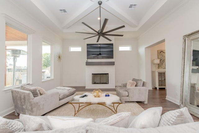 living room featuring ornamental molding, beamed ceiling, hardwood / wood-style flooring, and ceiling fan