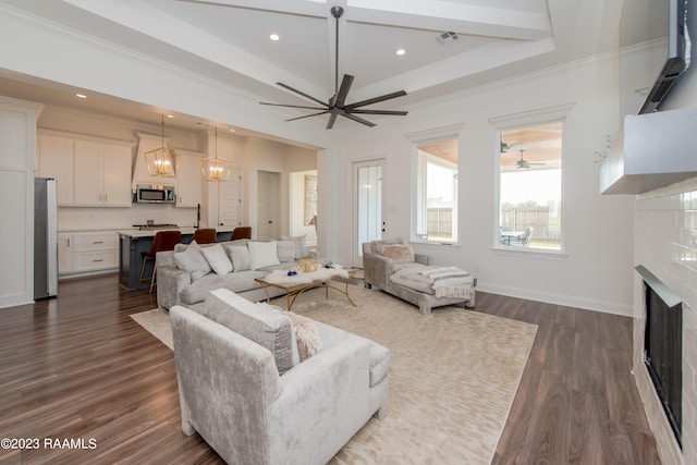 living room with dark hardwood / wood-style floors, crown molding, and ceiling fan with notable chandelier