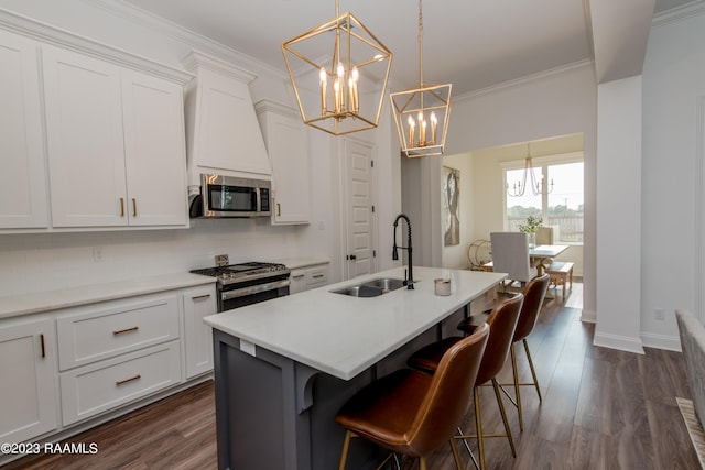 kitchen with stainless steel appliances, sink, white cabinets, dark wood-type flooring, and a kitchen island with sink