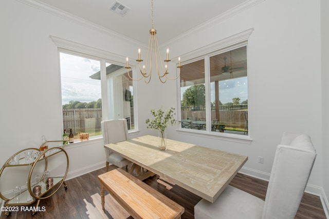 dining space with dark hardwood / wood-style floors, an inviting chandelier, and crown molding