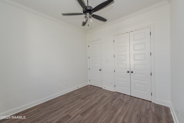 unfurnished bedroom with a closet, crown molding, ceiling fan, and dark hardwood / wood-style floors