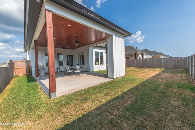 back of property featuring ceiling fan, a lawn, and a patio area