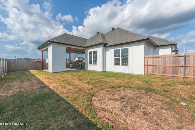 back of property with a yard and a patio area