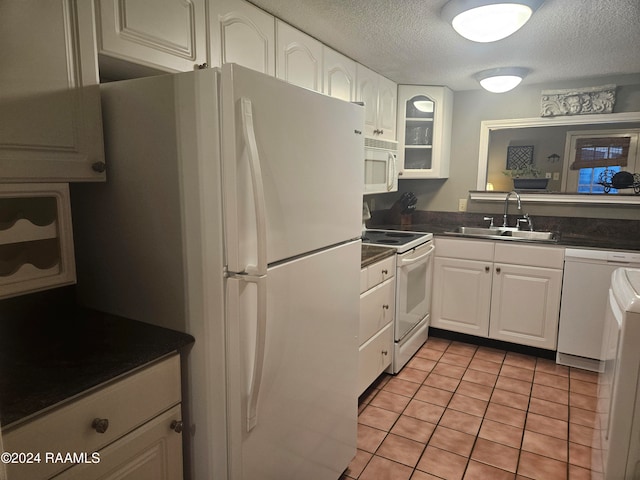 kitchen with white cabinetry, a textured ceiling, sink, and white appliances