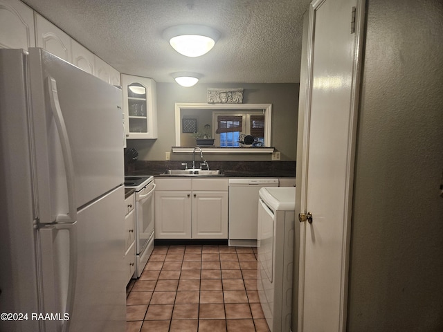 1318 Dulles Dr Unit B, Lafayette, LA 70506 - kitchen with white appliances, washer / dryer, white cabinetry, a textured ceiling, and dark countertops