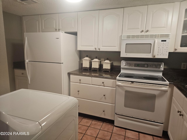 kitchen featuring white cabinets, washer / clothes dryer, a textured ceiling, and white appliances