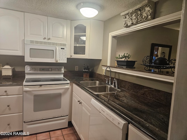 kitchen featuring light tile patterned flooring, a textured ceiling, sink, white cabinets, and white appliances