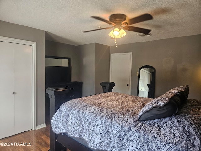 bedroom with ceiling fan, a textured ceiling, a closet, and wood-type flooring