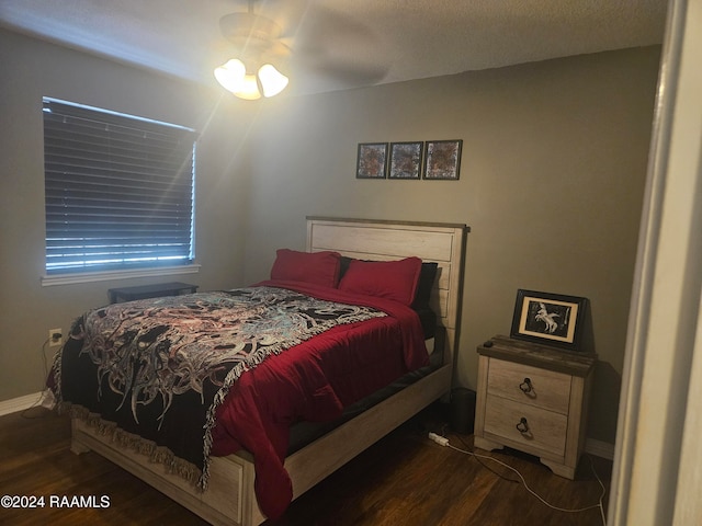 bedroom with dark hardwood / wood-style floors and ceiling fan