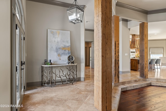 corridor featuring crown molding and a notable chandelier