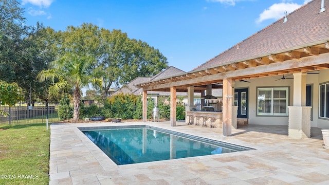 view of pool with a bar, ceiling fan, and a patio