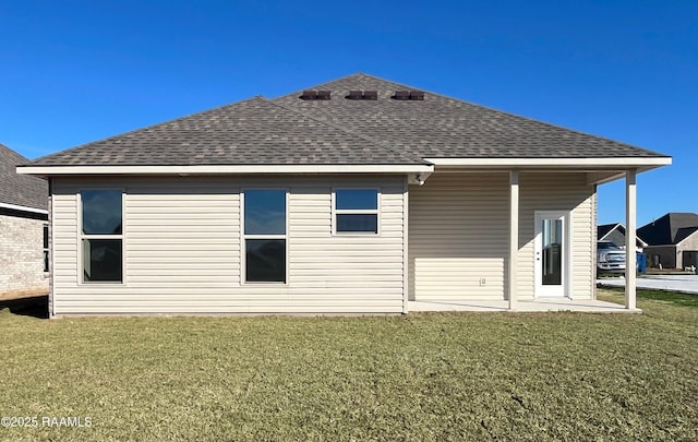 rear view of property featuring a lawn