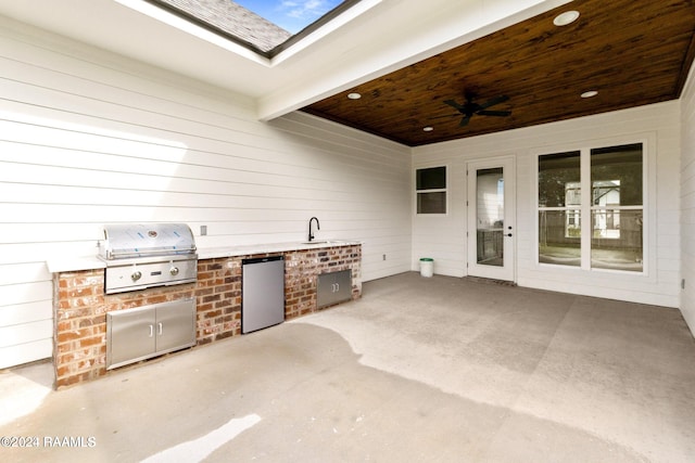 view of patio with grilling area, sink, an outdoor kitchen, and ceiling fan