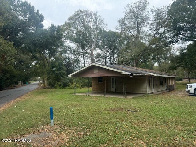 exterior space featuring a front lawn and a carport