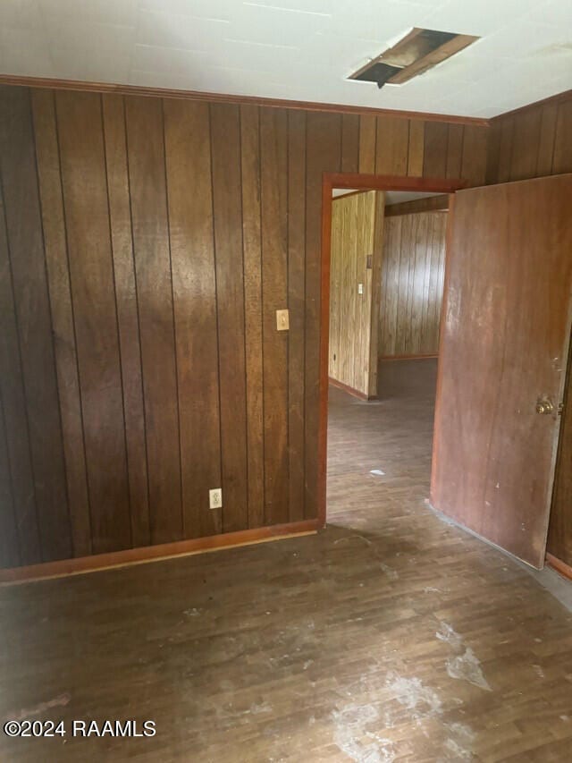 empty room featuring dark hardwood / wood-style flooring and wood walls