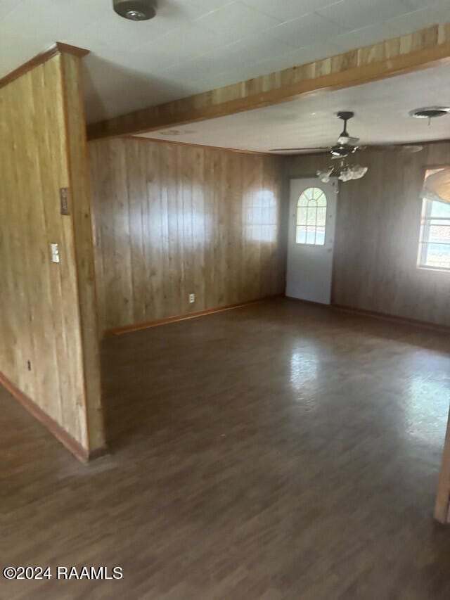 spare room with dark wood-type flooring and plenty of natural light