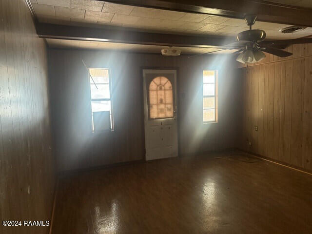 interior space featuring a wealth of natural light, wood-type flooring, beamed ceiling, and ceiling fan