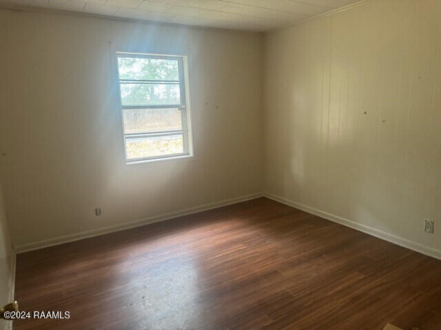 empty room with dark hardwood / wood-style flooring