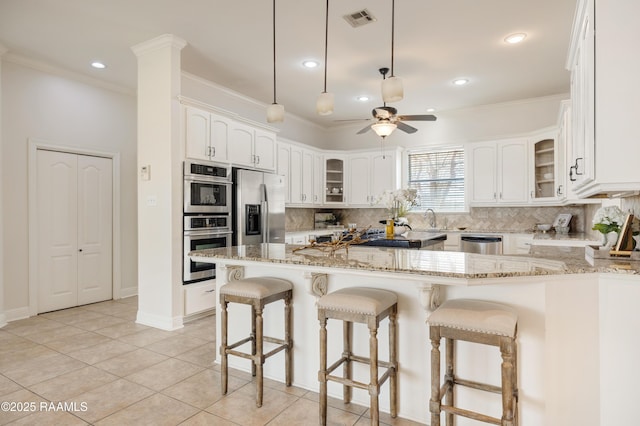 kitchen with white cabinetry, tasteful backsplash, stainless steel appliances, and light stone counters