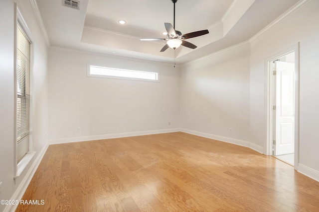 spare room with crown molding, ceiling fan, light wood-type flooring, and a tray ceiling