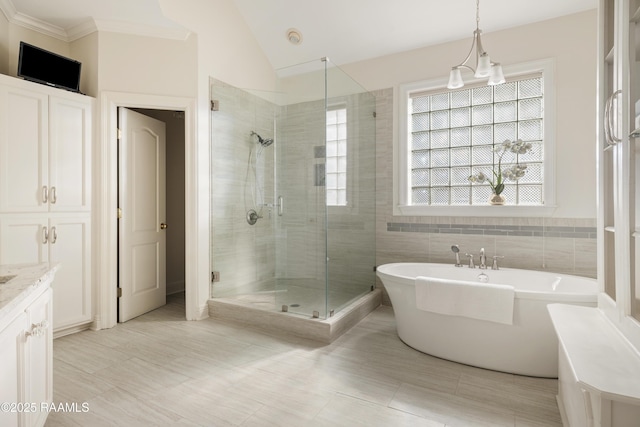 bathroom featuring vanity, plenty of natural light, lofted ceiling, and independent shower and bath