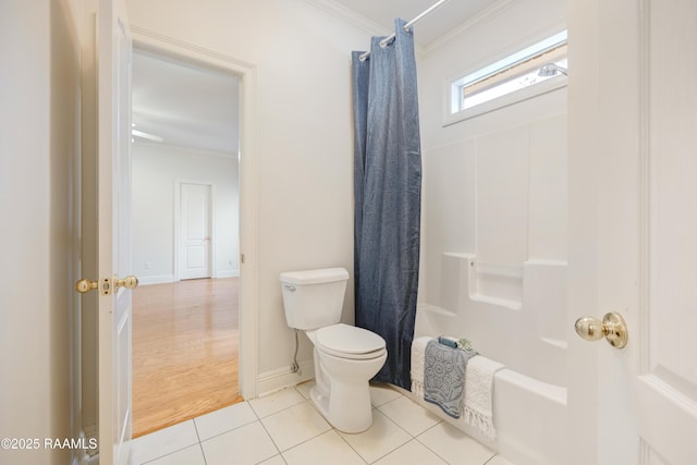 bathroom featuring crown molding, tile patterned floors, toilet, and shower / bath combo with shower curtain