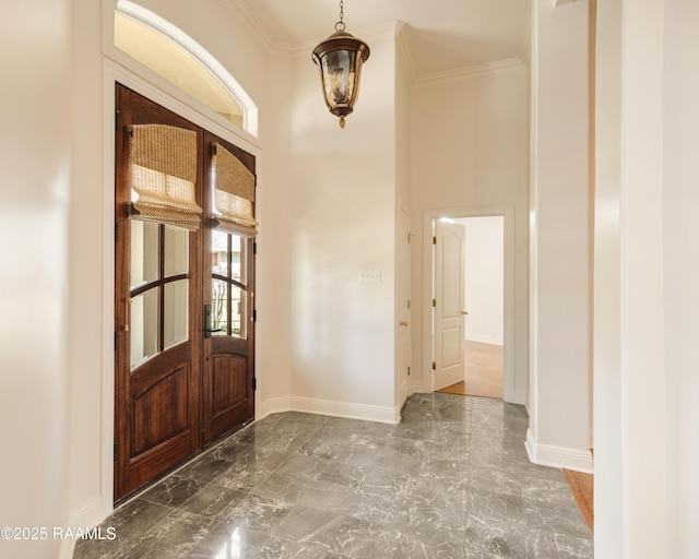 foyer with crown molding and a towering ceiling